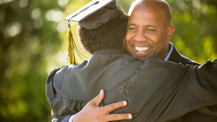Education plans – graduate hugging father